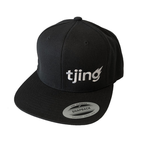 Black hat with white Tjing logo embroidery on the side front panel, snapback enclosure in the back – one size fits most.